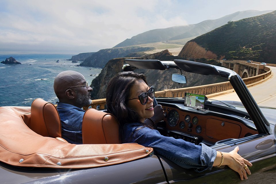 A couple enjoying a drive in their convertible equipped with Garmin sat nav.